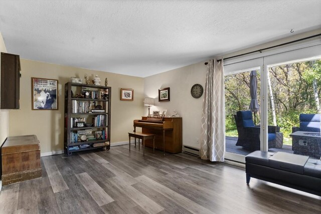 2146 Aster Pl Unit 3, Steamboat Springs, CO 80487 - sitting room featuring dark wood-type flooring, a textured ceiling, baseboard heating, and baseboards