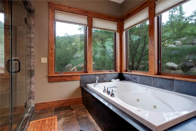 35525 Humble Rd, Steamboat Springs, CO 80487 - full bathroom featuring plenty of natural light, stone tile flooring, and a whirlpool tub