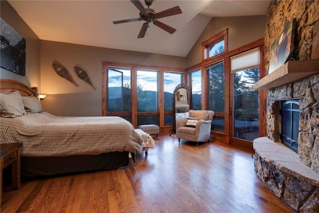 35525 Humble Rd, Steamboat Springs, CO 80487 - bedroom with access to outside, a fireplace, wood finished floors, high vaulted ceiling, and a ceiling fan