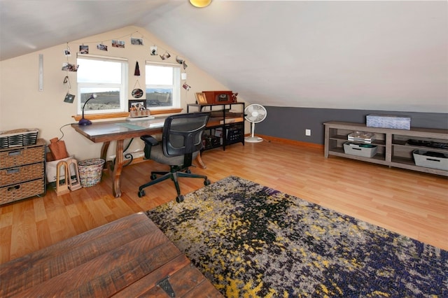 office space featuring vaulted ceiling, wood finished floors, and baseboards