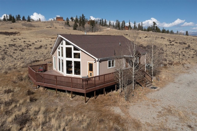 back of house with a wooden deck and a rural view