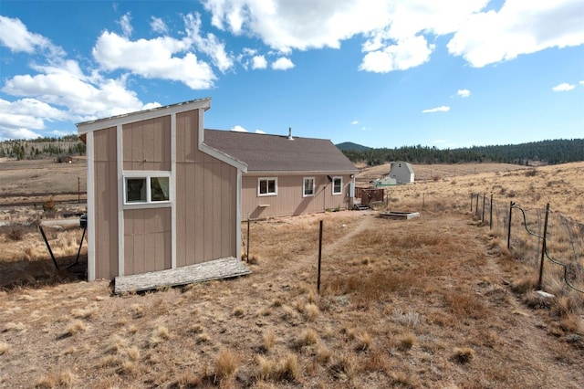 back of house featuring fence, an outbuilding, and a storage unit