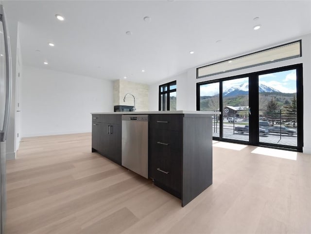740 Blue River Pkwy Unit A22, Silverthorne, CO 80498 - kitchen with stainless steel appliances, modern cabinets, light wood-style flooring, a sink, and dark cabinets