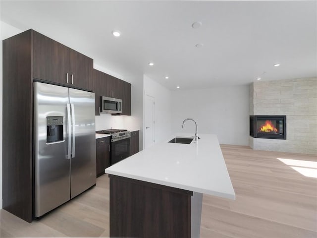 740 Blue River Pkwy Unit A22, Silverthorne, CO 80498 - kitchen featuring stainless steel appliances, a sink, light wood-style floors, dark brown cabinets, and recessed lighting