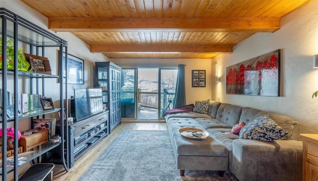 living area with wood ceiling, a textured wall, wood finished floors, and beam ceiling