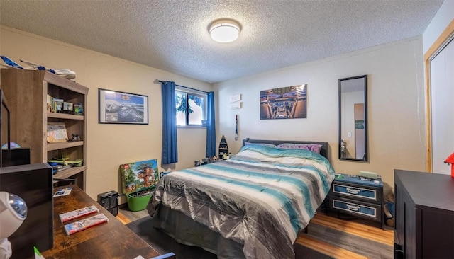 bedroom featuring wood finished floors and a textured ceiling