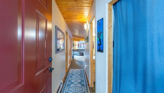 corridor featuring wood ceiling, baseboards, and a baseboard heating unit