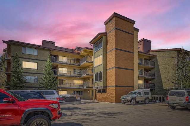 view of apartment building / complex with uncovered parking