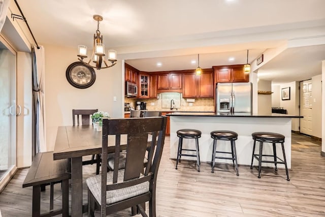 dining area with light wood-style floors and a chandelier