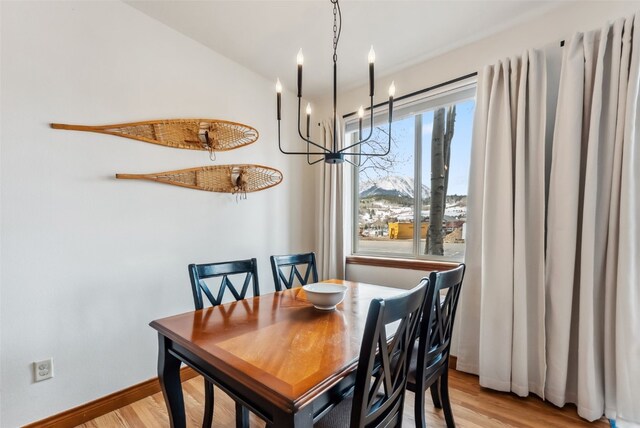 850 Blue River Pkwy Unit E5, Silverthorne, CO 80498 - dining area with baseboards, a chandelier, and light wood finished floors