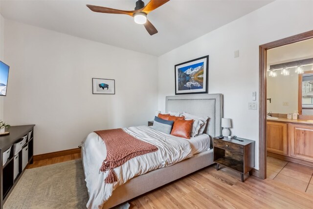 850 Blue River Pkwy Unit E5, Silverthorne, CO 80498 - bedroom with ceiling fan, baseboards, ensuite bathroom, and light wood-style flooring
