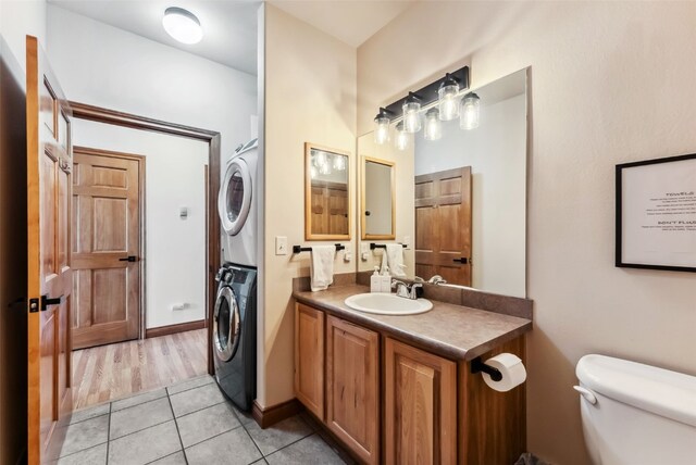 850 Blue River Pkwy Unit E5, Silverthorne, CO 80498 - bathroom featuring toilet, tile patterned floors, stacked washing maching and dryer, and vanity