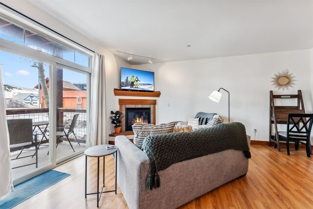 850 Blue River Pkwy Unit E5, Silverthorne, CO 80498 - living room with light wood-style floors, rail lighting, and a tiled fireplace