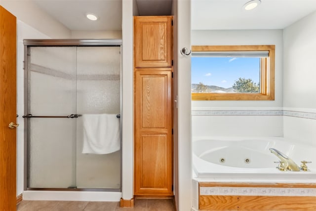 bathroom with a shower stall, a tub with jets, tile patterned floors, and recessed lighting