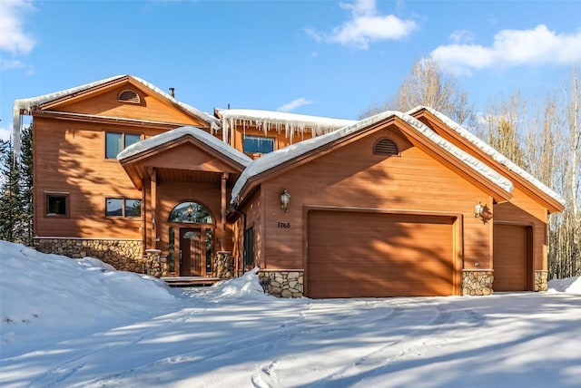 chalet / cabin featuring stone siding and an attached garage