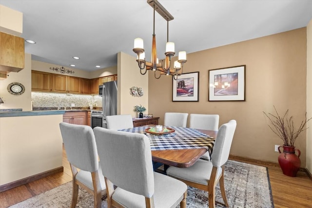 1675 Ranch Rd Unit 410, Steamboat Springs, CO 80487 - dining space featuring a chandelier, baseboards, recessed lighting, and light wood finished floors