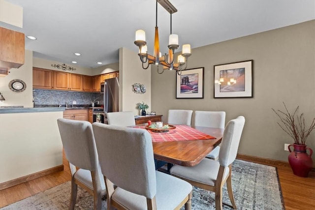 1675 Ranch Rd Unit 410, Steamboat Springs, CO 80487 - dining room featuring a chandelier, baseboards, light wood-type flooring, and recessed lighting