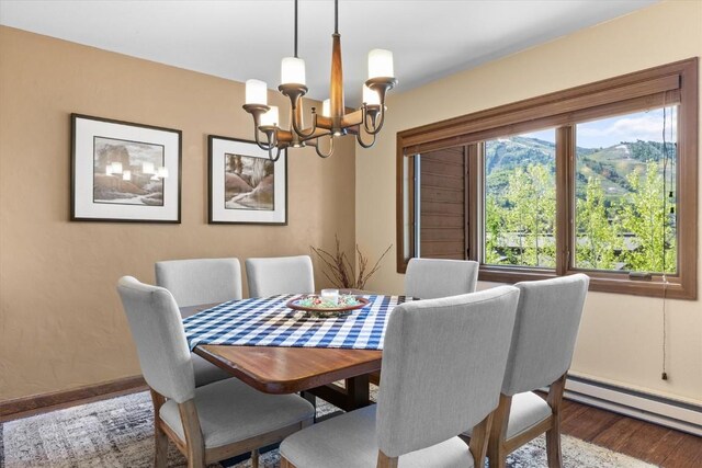 1675 Ranch Rd Unit 410, Steamboat Springs, CO 80487 - dining space featuring baseboard heating, a chandelier, baseboards, and wood finished floors