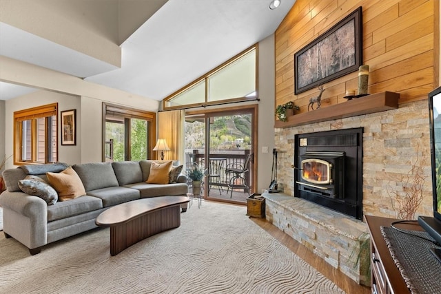 1675 Ranch Rd Unit 410, Steamboat Springs, CO 80487 - living area featuring wood finished floors, high vaulted ceiling, a stone fireplace, and wooden walls