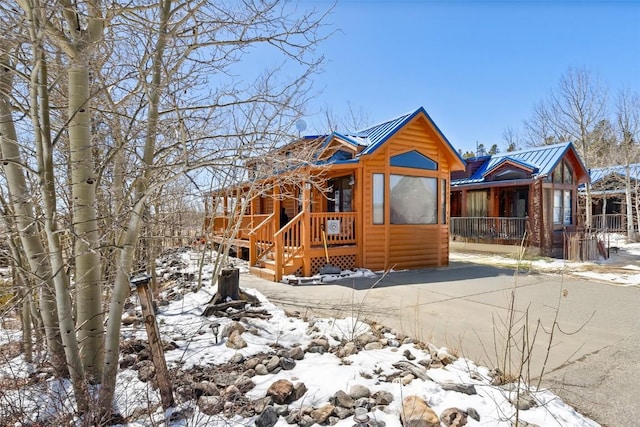 view of front of home featuring log veneer siding and metal roof