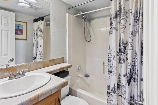 bathroom with vanity, shower / bath combination with curtain, a textured wall, toilet, and visible vents