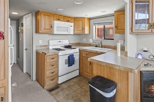 kitchen featuring a sink, white appliances, light countertops, visible vents, and recessed lighting