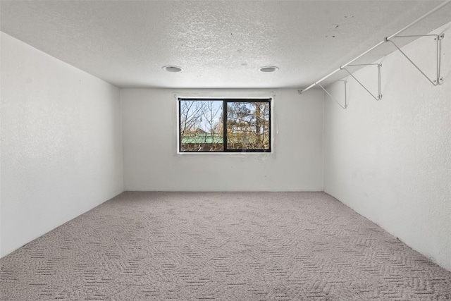 spare room featuring carpet and a textured ceiling