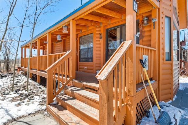 snow covered deck featuring covered porch