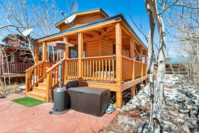 exterior space with a wooden deck and log veneer siding