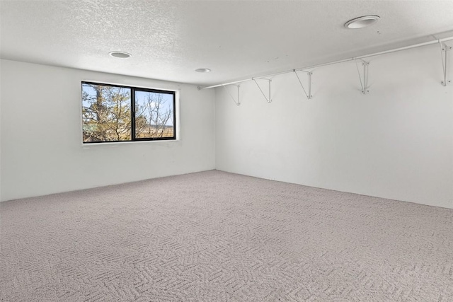 empty room with carpet floors and a textured ceiling