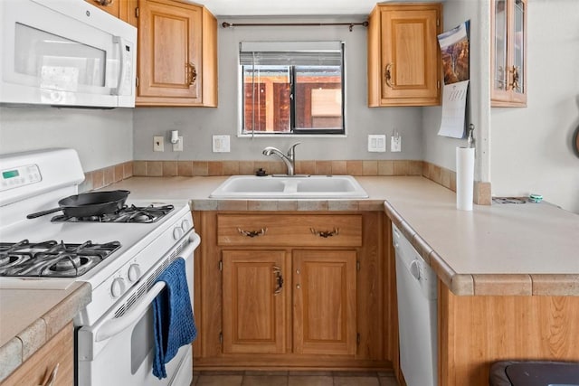 kitchen featuring light countertops, a sink, and white appliances