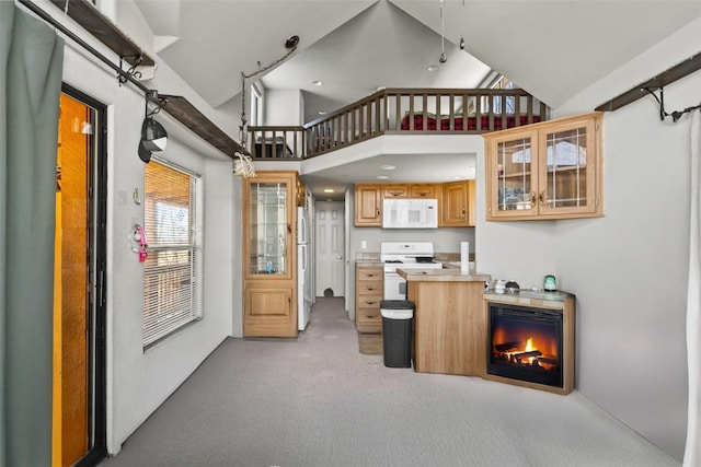 interior space with a towering ceiling, light colored carpet, and a lit fireplace