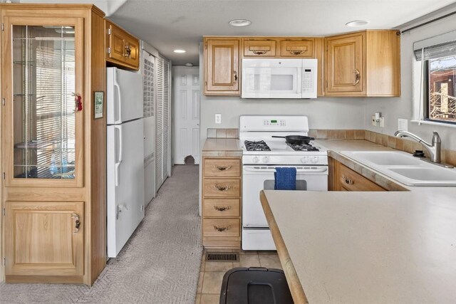 kitchen featuring a sink, white appliances, light carpet, light countertops, and recessed lighting