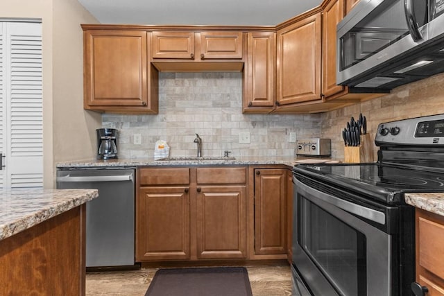 2626 Longthong Rd Unit 203, Steamboat Springs, CO 80487 - kitchen featuring light stone counters, a sink, appliances with stainless steel finishes, and tasteful backsplash
