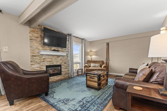 2626 Longthong Rd Unit 203, Steamboat Springs, CO 80487 - living area featuring wood finished floors, beamed ceiling, and a fireplace
