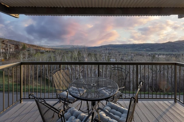 2626 Longthong Rd Unit 203, Steamboat Springs, CO 80487 - deck at dusk featuring a mountain view and outdoor dining space