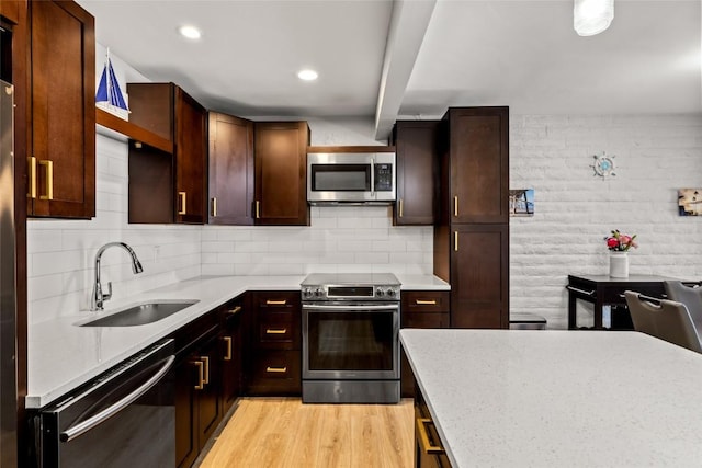 13 Cedar Ct Unit 13, Steamboat Springs, CO 80487 - kitchen featuring appliances with stainless steel finishes, light wood finished floors, tasteful backsplash, dark brown cabinetry, and recessed lighting