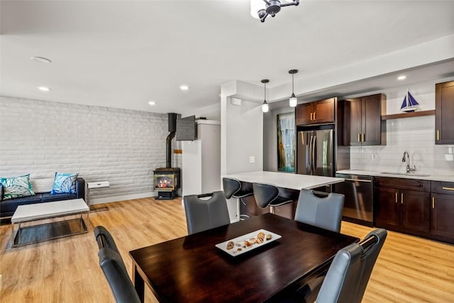 13 Cedar Ct Unit 13, Steamboat Springs, CO 80487 - dining room featuring a wood stove, brick wall, light wood-style floors, and recessed lighting