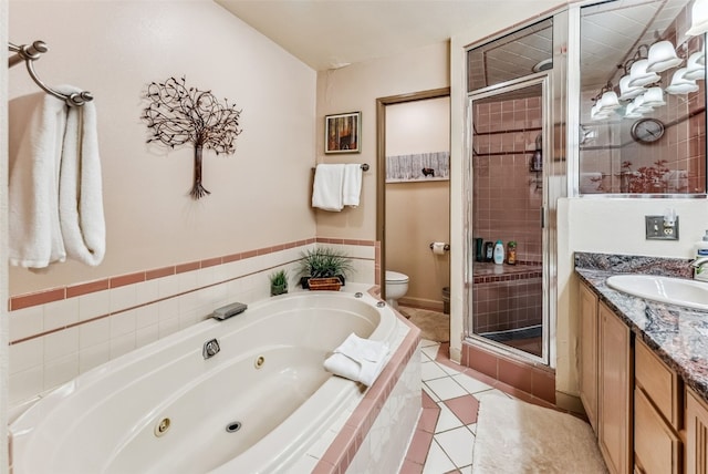 bathroom with tile patterned flooring, a whirlpool tub, toilet, vanity, and a stall shower
