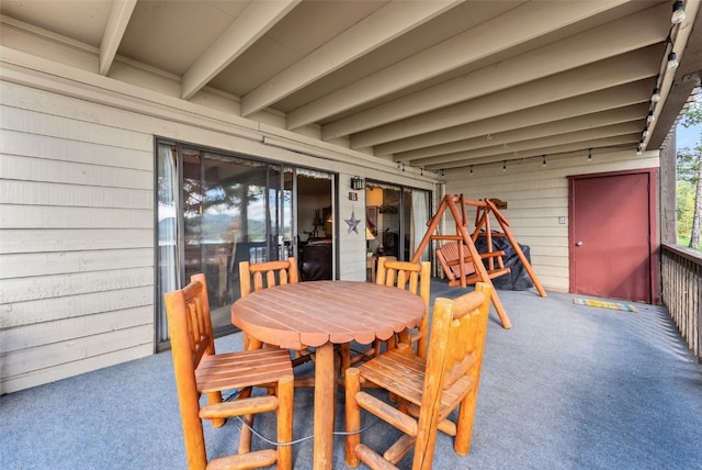 exterior space with beamed ceiling and wood walls