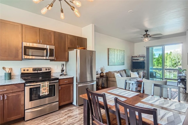 835 Weiss Cir Unit 2, Steamboat Springs, CO 80487 - kitchen featuring appliances with stainless steel finishes, a chandelier, light wood-style floors, open floor plan, and ceiling fan