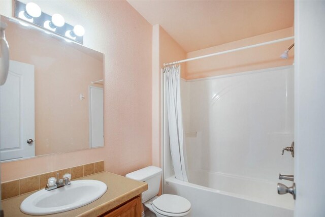 full bathroom featuring vanity, shower / bath combo with shower curtain, and toilet