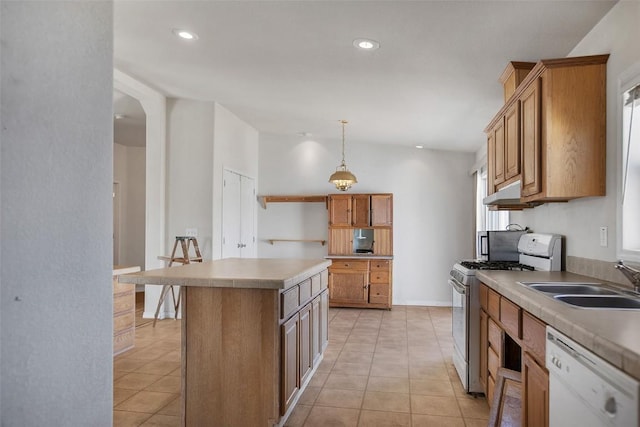 kitchen with white appliances, light tile patterned floors, a kitchen island, and a sink