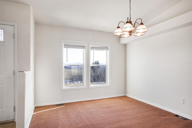 carpeted spare room with baseboards, visible vents, and a chandelier