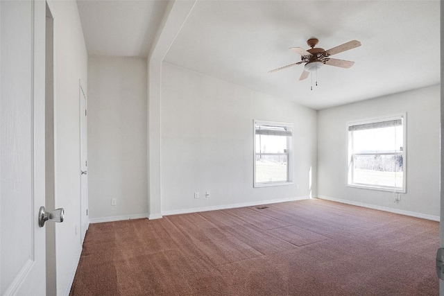 carpeted empty room featuring a ceiling fan and baseboards