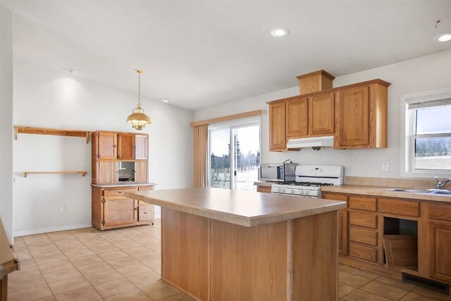 kitchen featuring a sink, light countertops, a center island, white gas stove, and under cabinet range hood