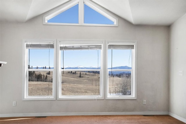 empty room with baseboards, plenty of natural light, a mountain view, and visible vents