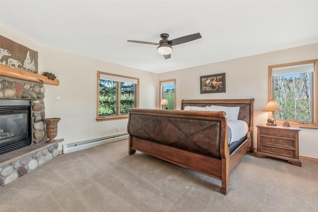 bedroom with carpet floors, a baseboard heating unit, and multiple windows