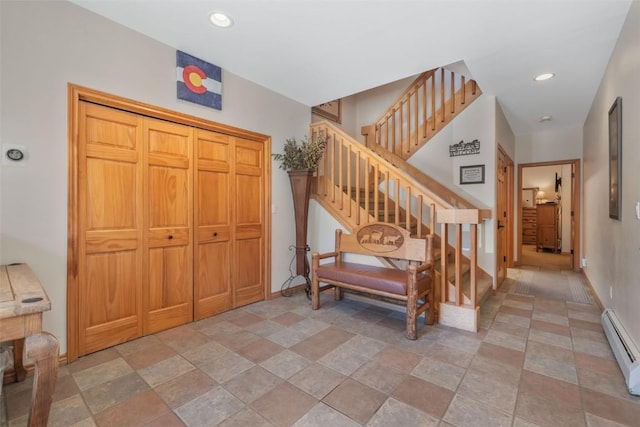 staircase with stone finish floor, baseboards, a baseboard heating unit, and recessed lighting