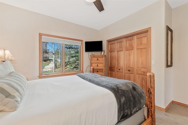 carpeted bedroom with baseboards, ceiling fan, and a closet